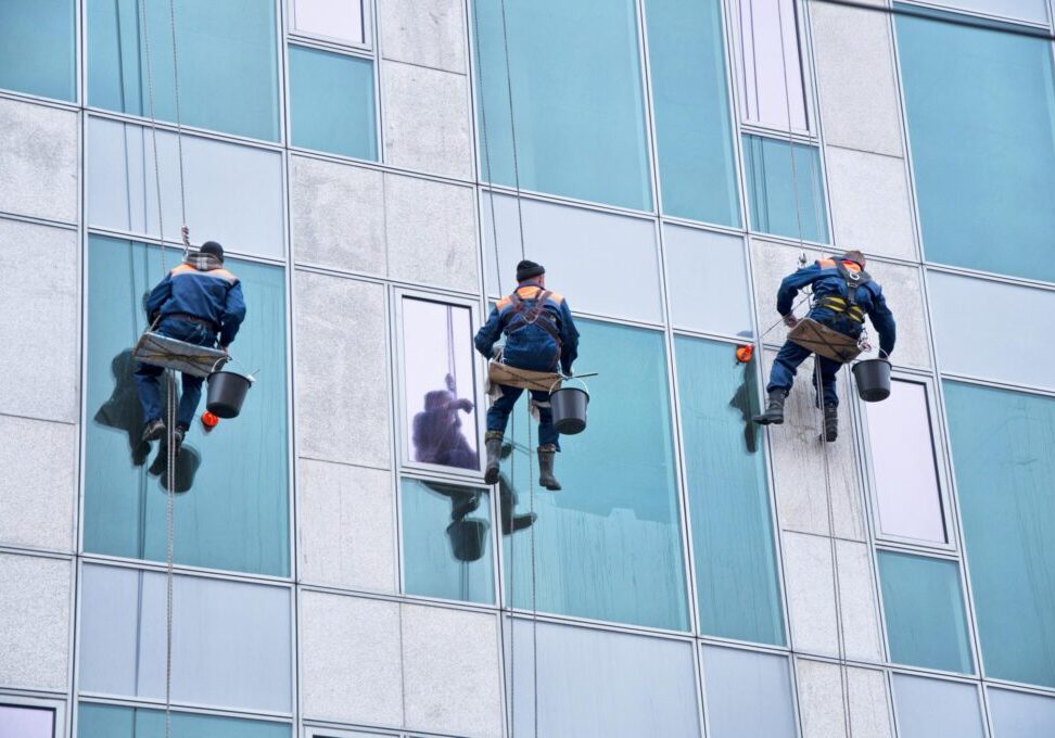 cleaners with harness cleaning the building windows